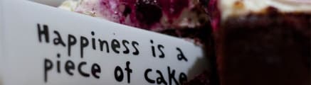 Cake with a cutout that says 'Happiness is a piece of cake'