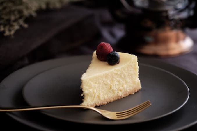 cheesecake with a raspberry and blueberry on top on a plate